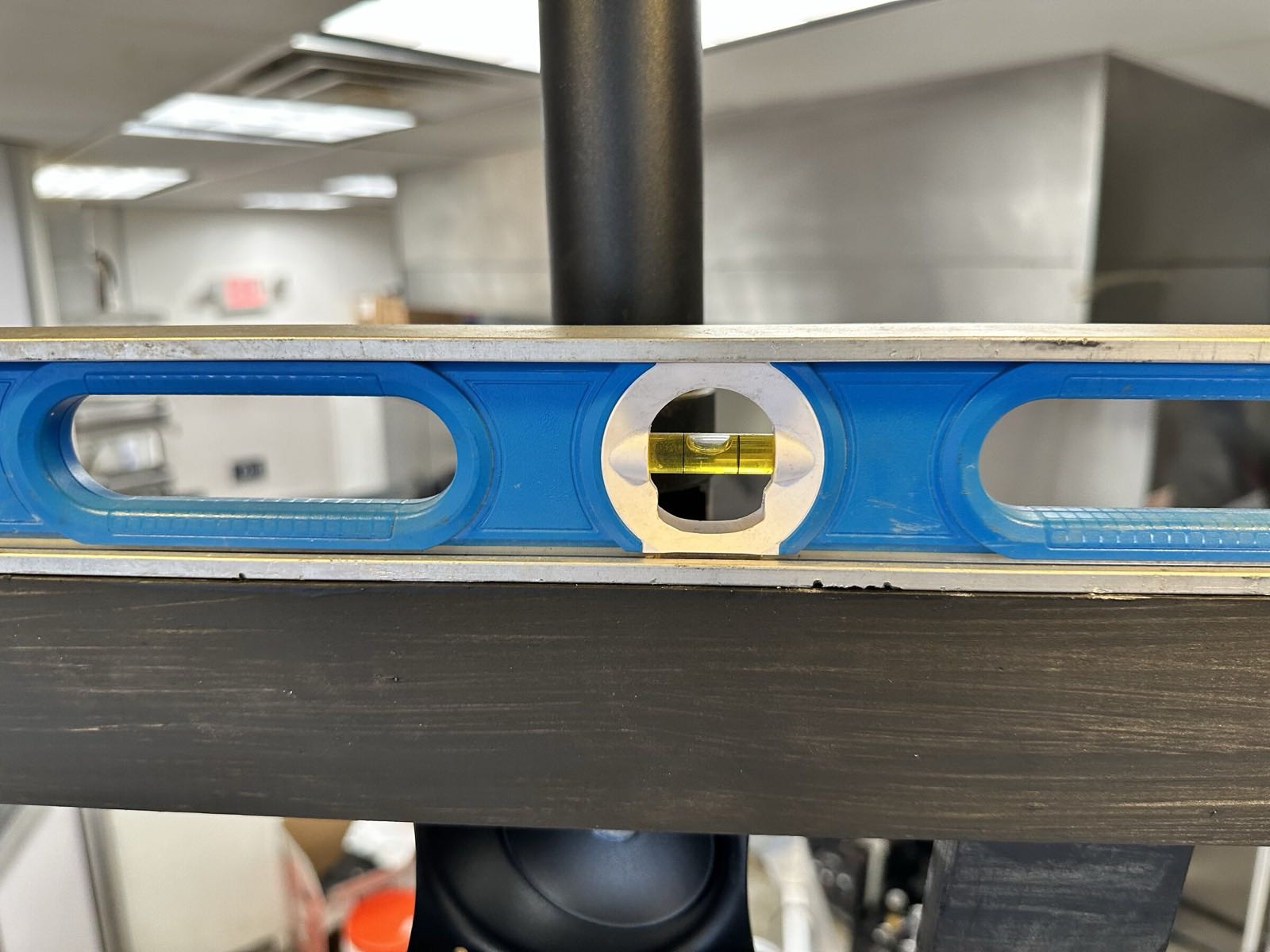 Spirit level resting on a display mounting rail during a SmoothLayers installation